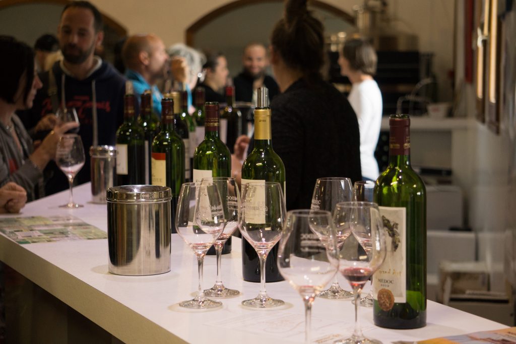 Bouteilles et verre de vin pour une dégustation des vins du Médoc par UNI MEDOC